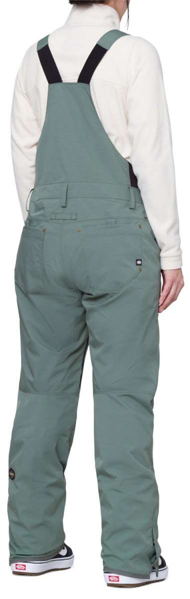 The 686 Women's Black Magic Insulated Bib appears to be all black with a zippered fly and adjustable side straps.