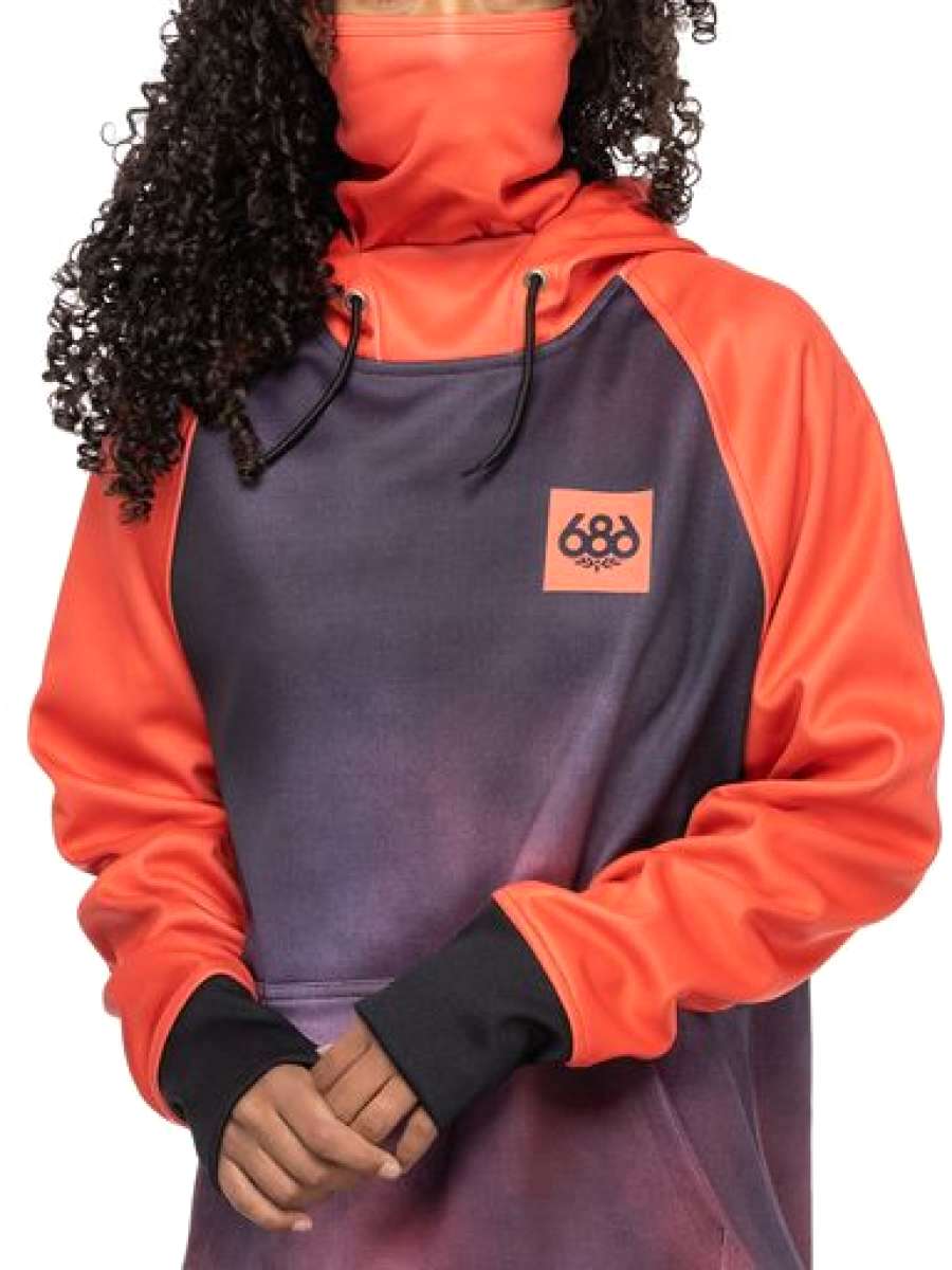 A woman wearing a grey and coral hooded sweatshirt with an orange logo on the front.