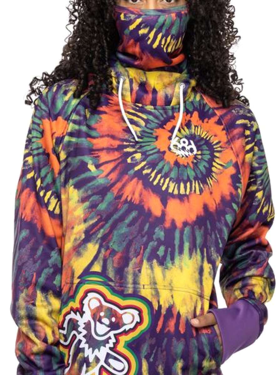 The 686 Ladies Bonded Fleece Pull Over Hoodie 2023 features a vibrant multicolored tie-dye pattern with an orange and yellow spiral design on the front.