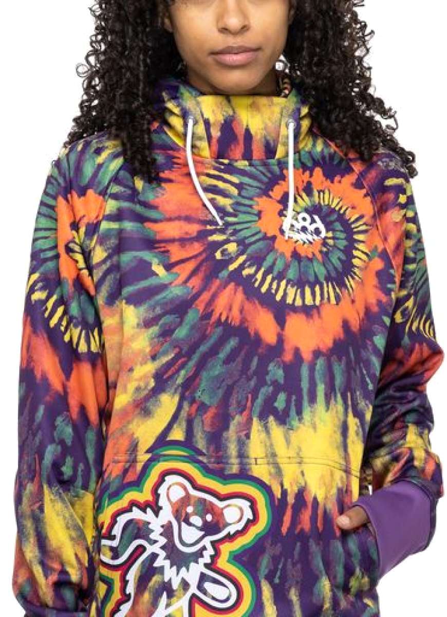 The 686 Ladies Bonded Fleece Pull-Over Hoodie features a vibrant purple, orange, yellow, and green tie-dye design with an insulated hood.