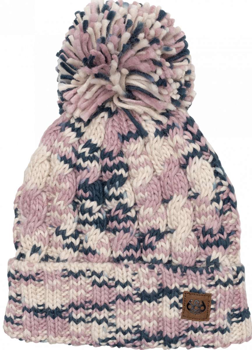The 686 Ladies Chunky Rib Cuffed Beanie 2024 is predominantly pink and white with dark blue accents, featuring a chunky knit pattern and a cuffed hem.