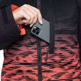 The 686 Dream Insulated Jacket, designed for women, showcases a black and salmon-colored ombre pattern with an orange lining visible on the left sleeve.