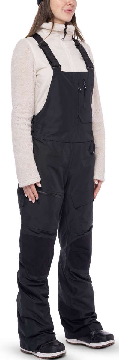 The women's 686 Geode Thermagraph bib features a black insulated snowboard bib with a zippered fly and adjustable straps.