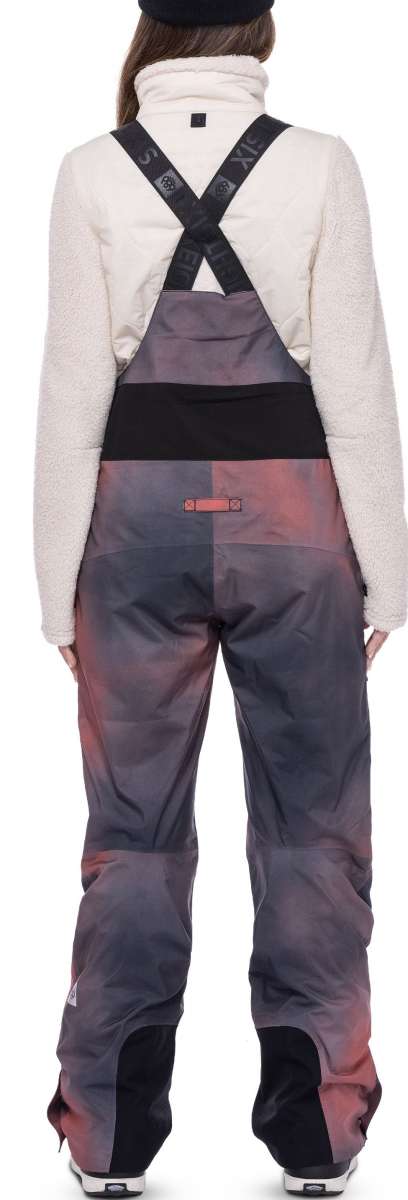 The 686 Women's Geode Thermagraph Bib 2023 features a gray and pink color scheme with an insulated hood.