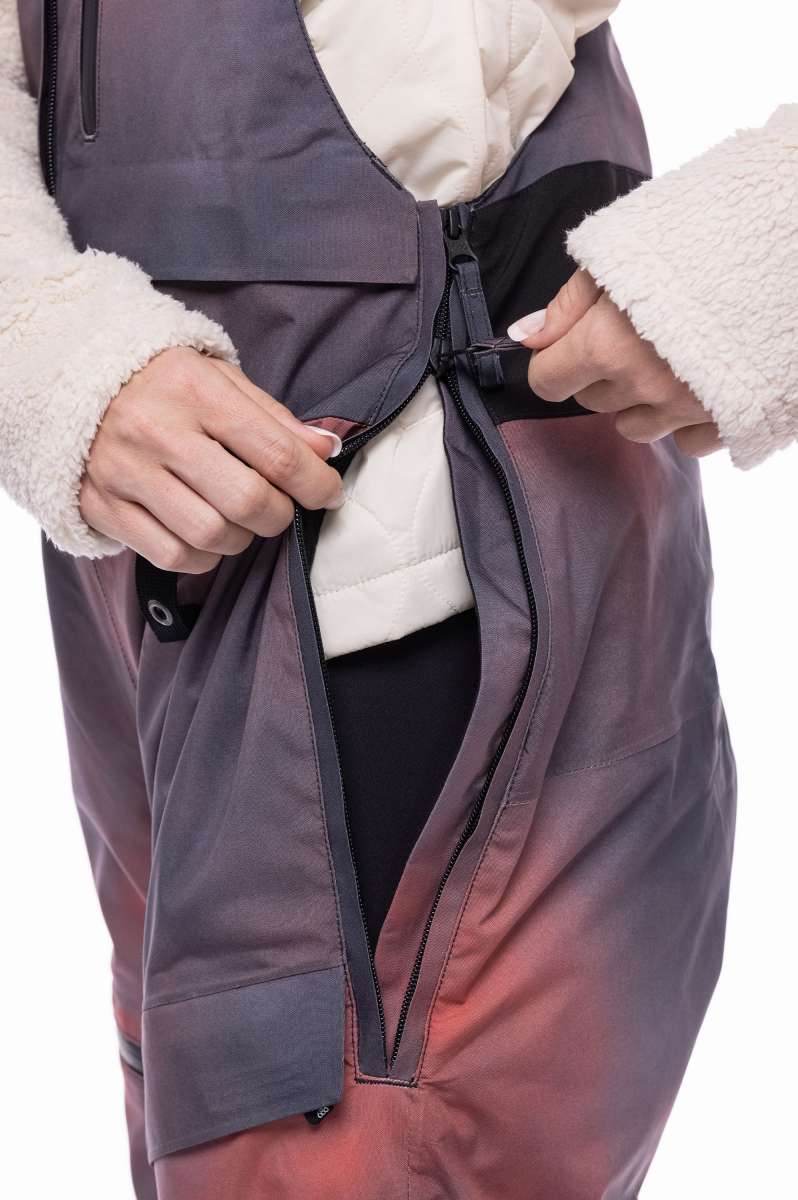 The 686 Women's Geode Thermagraph Bib 2023 in this image appears to be dark purple with an insulated white hood.