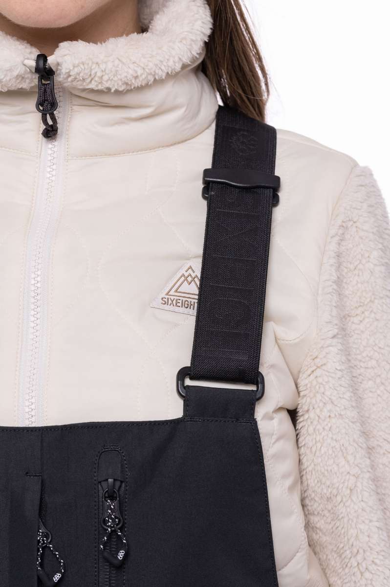 The 686 Women's Geode Thermagraph Bib features a black front with a quilted pattern and a white logo on the left hip.