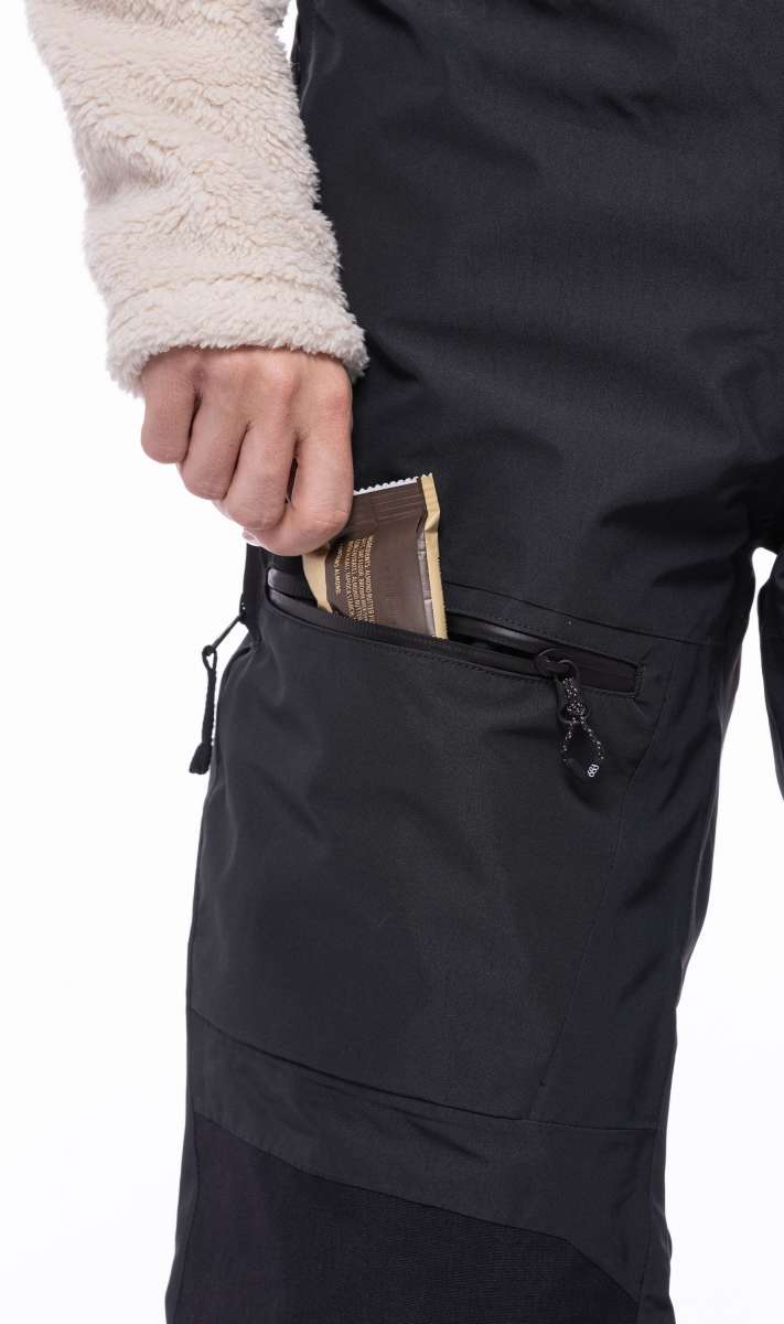 The 686 Women's Geode Thermagraph Bib from the waist down with black straps on the sides and a zippered pocket at the back.