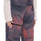 The women's bib snow pants are dark gray with a pinkish-red overlay and have zippered front pockets.
