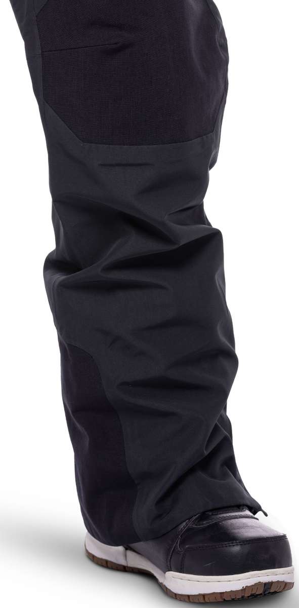 The 686 Women's Geode Thermagraph Bib 2023 is predominantly black with dark gray panels and a reflective safety logo on the left leg.