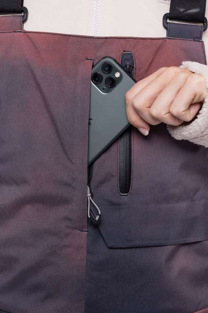 The 686 Women's Geode Thermagraph Bib 2023 is shown in dark gray with a burgundy stripe down the side.