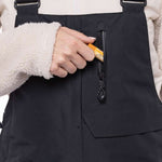 The 686 Women's Geode Thermagraph Bib 2023 is primarily black with an orange zipper and a black BOA dial.