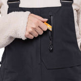 The 686 Women's Geode Thermagraph Bib 2023 is black with an insulated hood and zippered pockets.