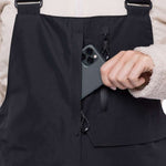 The 686 Women's Geode Thermagraph Bib has a solid black color with an insulated hood and is shown in a front view.