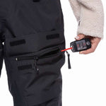 The 686 Women's Geode Thermagraph Bib 2023 is primarily black with an insulated hood and zippered leg pockets.