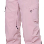 The 686 Women's Geode Thermagraph Pant 2024 is primarily light pink with black accents and a zippered pocket on the side.