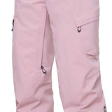 The 686 Women's Geode Thermagraph Pant 2024 is primarily light pink with black accents and a zippered pocket on the side.