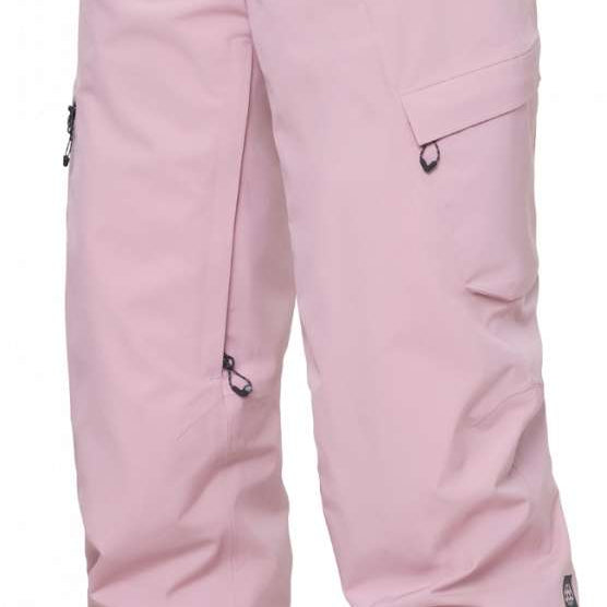 The 686 Women's Geode Thermagraph Pant 2024 is primarily light pink with black accents and a zippered pocket on the side.