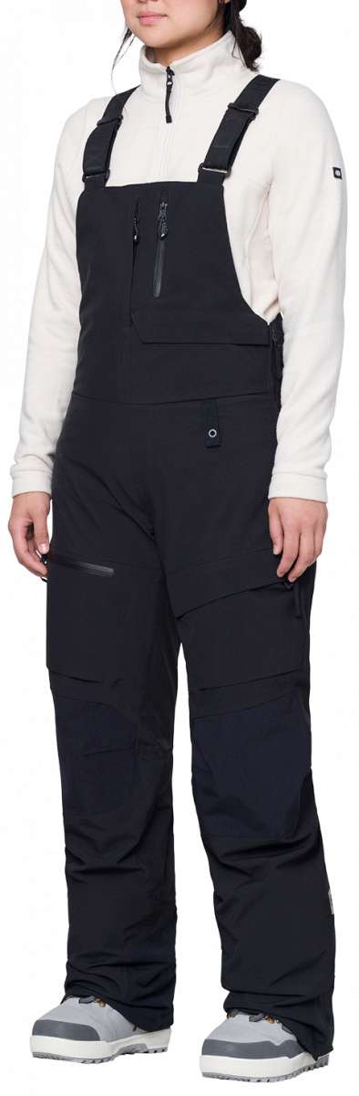 The 686 Women's Geodge Thermagraph Bib features black bib legs with a zippered front and a visible insulated thermal lining.