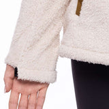 The 686 Ladies Hemlock Fleece Hoodie 2023 is shown in a cream color with a brown zipper and an insulated hood.