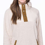 The 686 Ladies Hemlock Fleece Hoodie 2023 has an off-white body with brown accents and a hood.