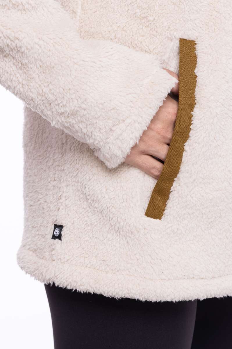 The 686 Ladies Hemlock Fleece Hoodie in cream has an insulated hood and a brown drawstring.