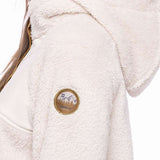 The 686 Ladies Hemlock Fleece Hoodie 2023 is cream-colored with a gold zipper and an embroidered patch on the upper arm.