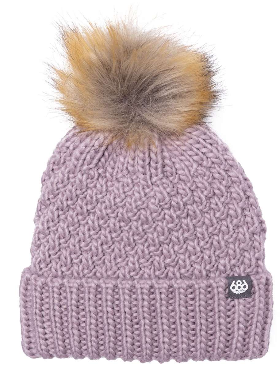 The 686 Ladies Majesty Cable Knit Beanie 2023 is dusty pink with a large faux fur pom-pom on top.