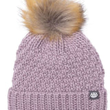 The 686 Ladies Majesty Cable Knit Beanie 2023 is dusty pink with a large faux fur pom-pom on top.
