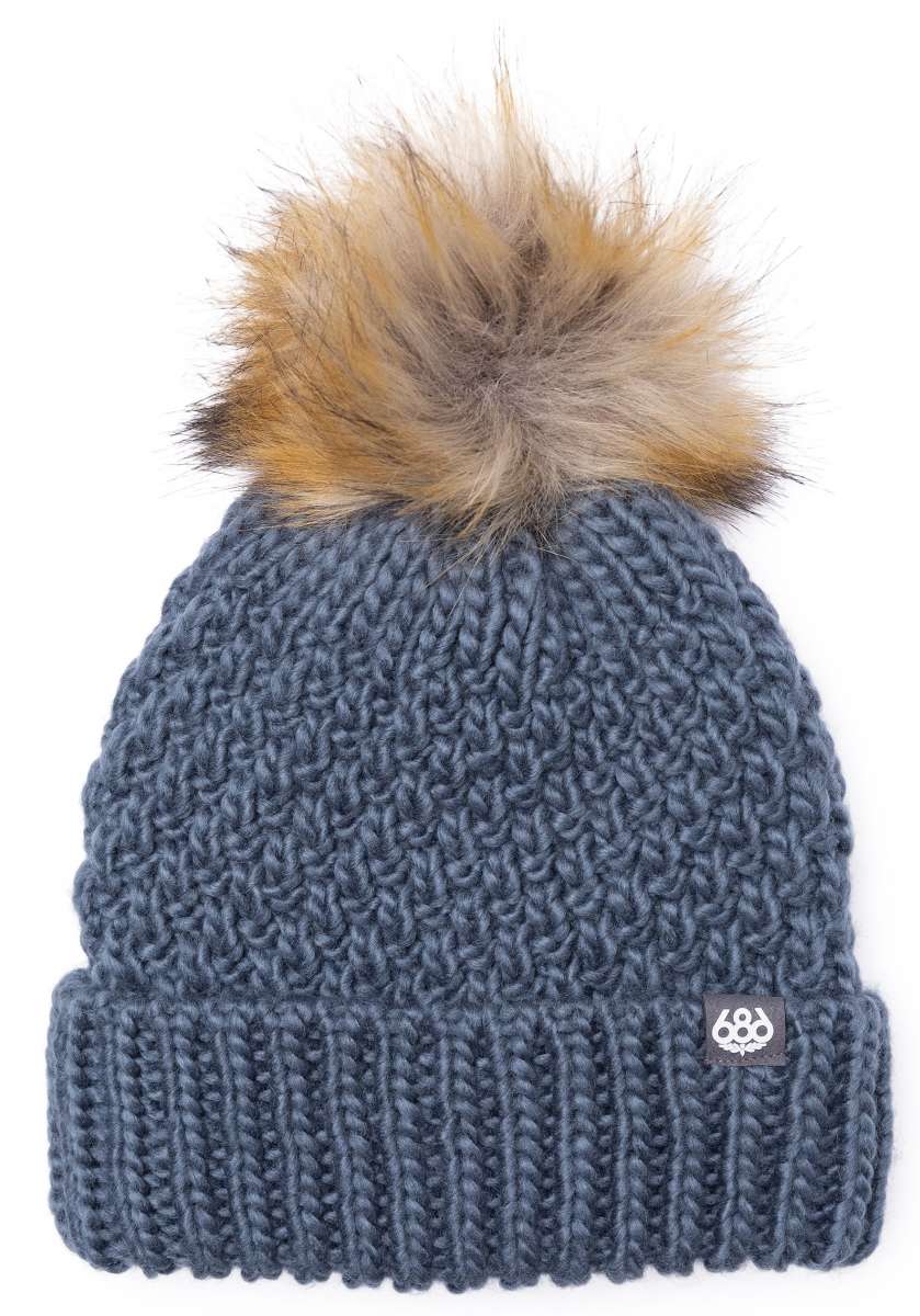 The 686 Majesty beanie is dark gray with a tan faux fur pom-pom on top.