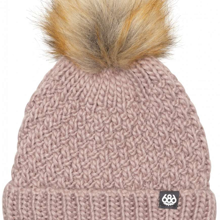 The 686 Ladies Majesty Cable Knit Beanie from the front view features a dusty rose color with a faux fur pom-pom on top.