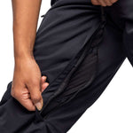 The 686 Women's Smarty 3-in-1 Cargo Pant 2024 is shown in black with a zippered fly and two zippered cargo pockets on each thigh.