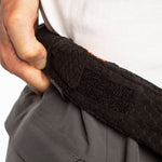 The 686 Quantum Thermagraph Pant in black has an orange stripe on the side and appears to be made from a thick, textured material with a fleece-like lining.