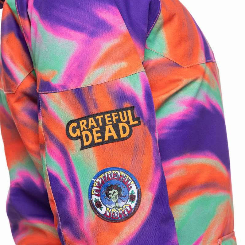 The 686 Ladies' Upton Insulated Jacket 2023 is primarily purple with an orange swirl pattern and has a hood.