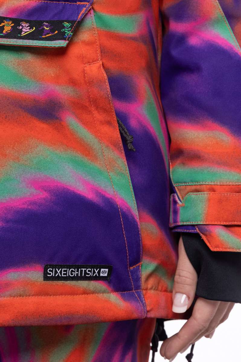 The 686 Ladies' Upton Insulated Jacket 2023 has an orange base color with purple swirls and a black logo on the left chest.