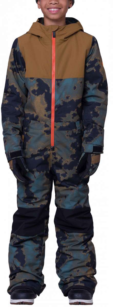 The 686 Boys Shazam Insulated One Piece Snowsuit has an all-over navy and brown camouflage pattern with a bright orange zipper running down the front.