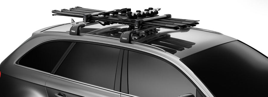 Thule Snowpack M 4 Pairs - This image shows a black roof rack with four pairs of skis mounted on top.