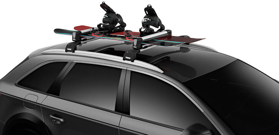 Thule Snowpack M 4 Pairs - 7324 - Black roof rack with four ski and snowboard carriers attached.