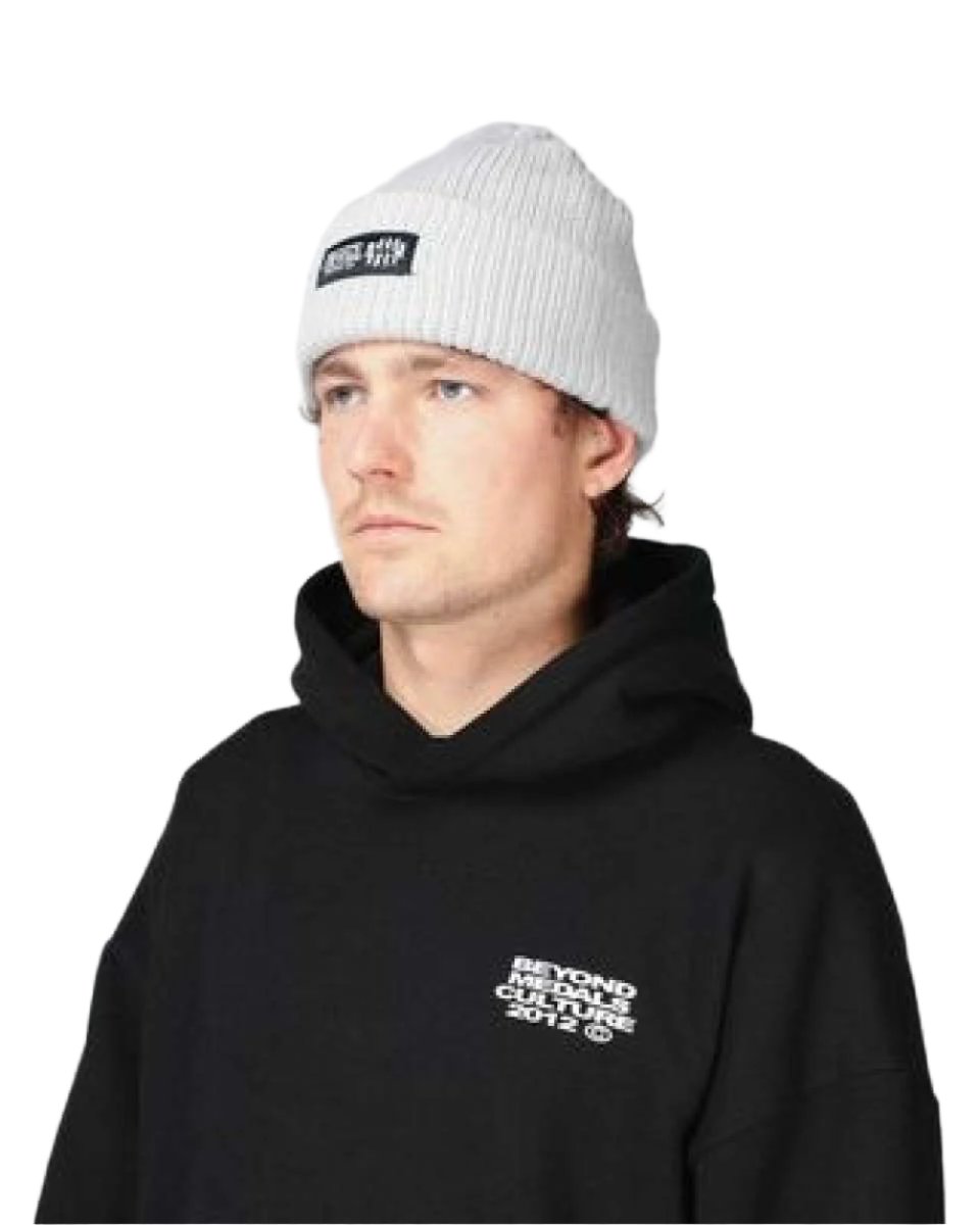 Beyond Medals Culture Beanie 2024 - A light gray beanie with a black rectangular patch on the front featuring white text that reads "BEYOND MEDALS CULTURE".