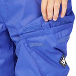 DC Junior's Banshee Insulated Pant 2023 - A pair of blue snow pants with a black logo patch on the left leg.