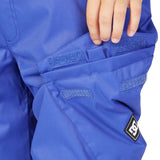 DC Junior's Banshee Insulated Pant 2023 - A pair of blue snow pants with a black logo patch on the left leg.