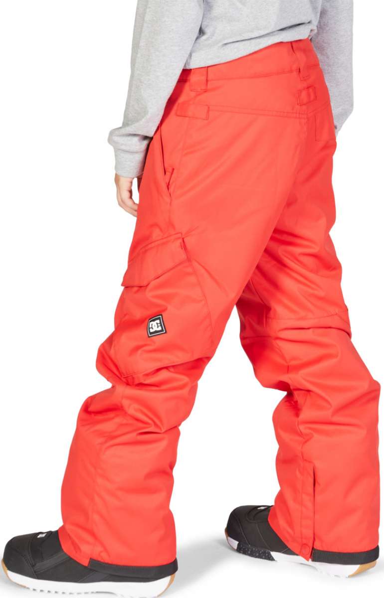 DC Junior's Banshee Insulated Pant - Pant is coral-colored with a black logo patch on the left leg and has a slight sheen to it.