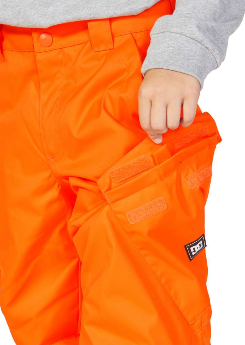 DC Junior's Banshee Insulated Pant 2023 - A pair of bright orange snow pants with a black and white logo on the left leg.