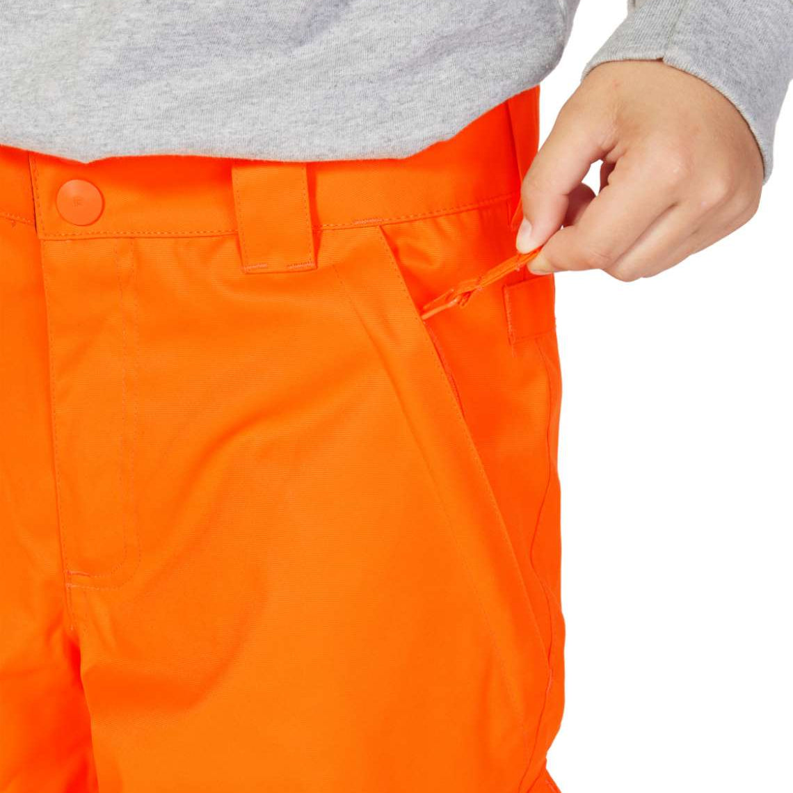 DC Junior's Banshee Insulated Pant 2023 - A pair of bright orange snow pants with a black stripe down the side and a zippered pocket on the thigh.