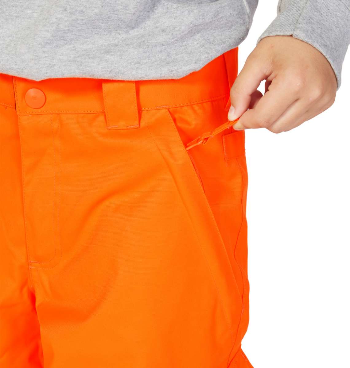 DC Junior's Banshee Insulated Pant 2023 - A pair of bright orange snow pants with a black stripe down the side and a zippered pocket on the thigh.
