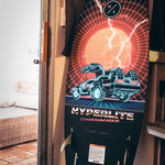 Hyperlite Time Machine Limited Edition Wakesurf Board 2022 - A black board with a red and white graphic of a DeLorean car, featuring a grid pattern background.