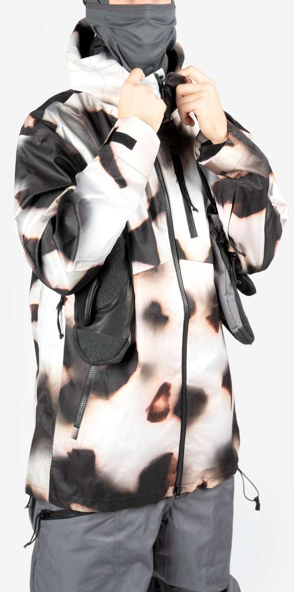 Endeavor 3L Shelter Shell Jacket 2024 - A black and white camouflage patterned jacket with a hood, zipper closure, and two zippered pockets on the front.