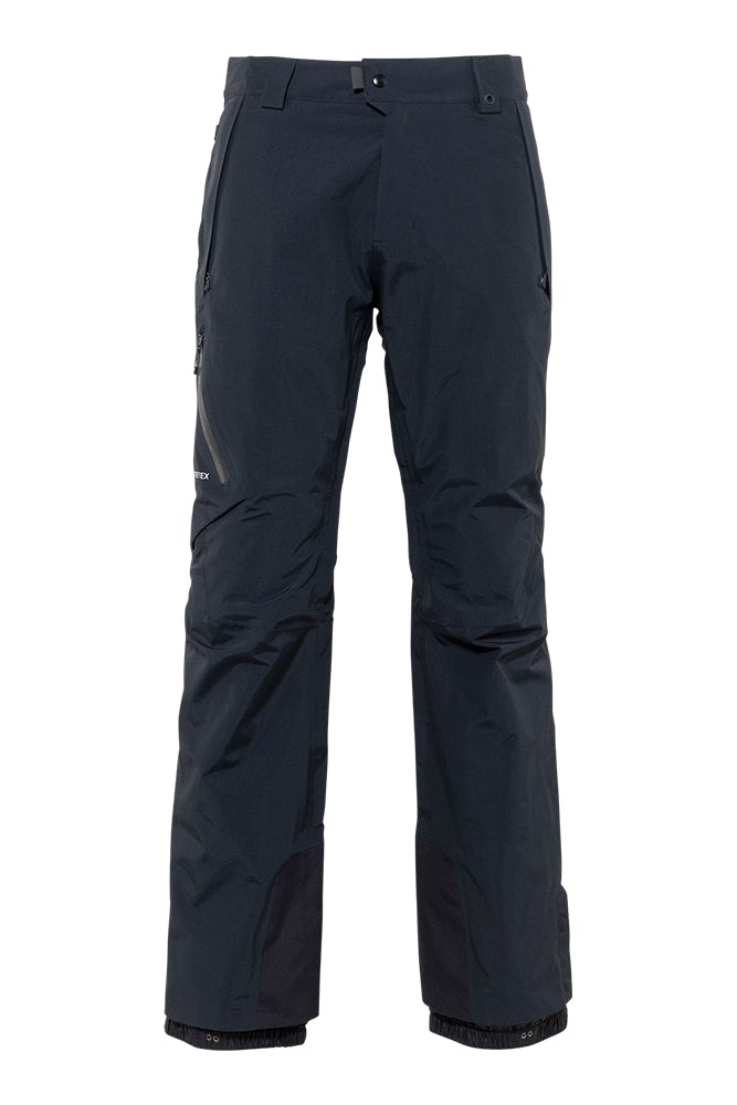 The 686 GLCR Gore-Tex GT Pant has a navy blue color with black accents and a zippered pocket on the side.