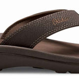 Olukai Ohana Sandals - A pair of brown sandals with a strap and toe post, featuring a logo on the side.