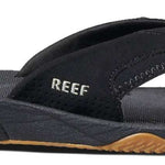 Reef Men's Fanning Sandal - A black sandal with a white logo on the strap and a brown sole.