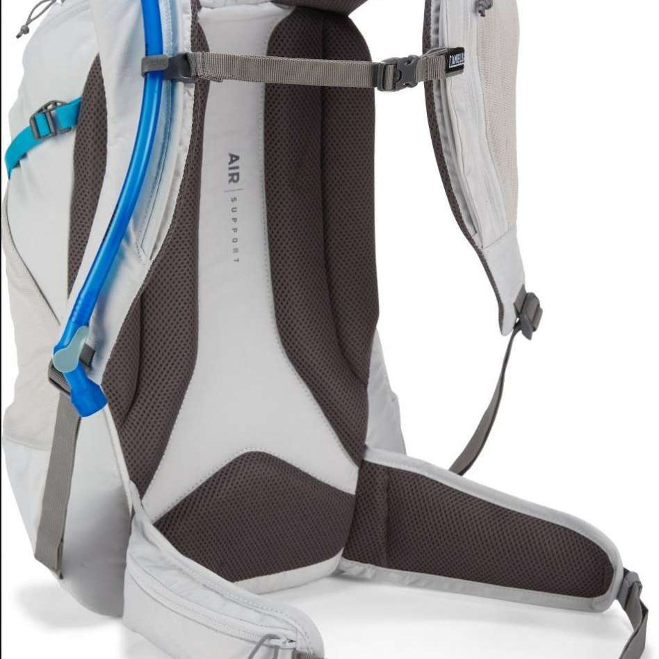 CamelBak Ladies Rim Runner X20 70oz Pack - A white backpack with a blue water hose and black straps.